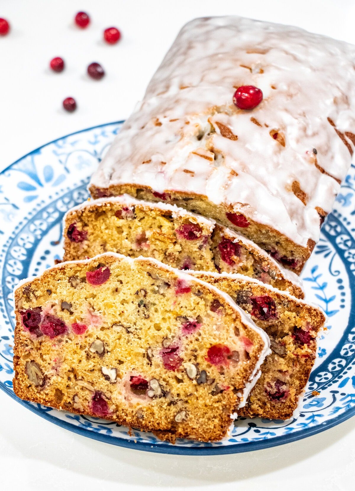 Bursting with cranberry and orange flavors and studded with pecans, this Cranberry Orange Bread with Lemon Glaze is not only pretty it is totally scrumptious! Quick and easy to make and freezable, too. Perfect as a Christmas or holiday gift.