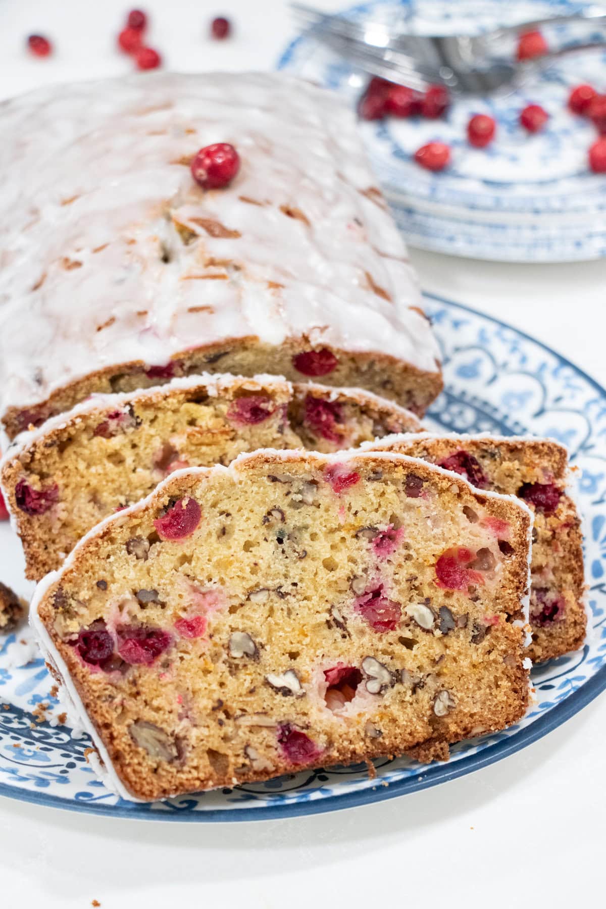 Bursting with cranberry and orange flavors and studded with pecans, this Cranberry Orange Bread with Lemon Glaze is not only pretty it is totally scrumptious! Quick and easy to make and freezable, too. Perfect as a Christmas or holiday gift.