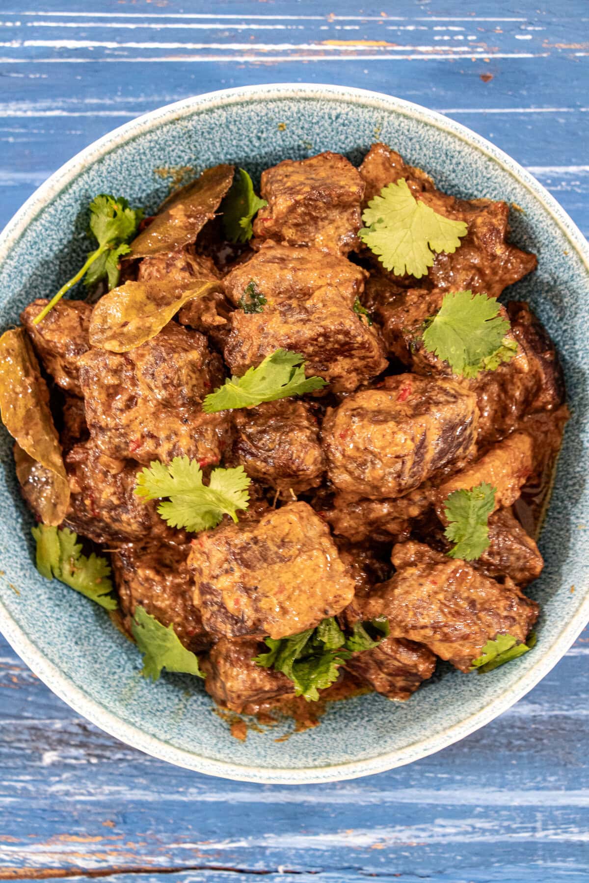 This classic Indonesian beef stew is slowly cooked in coconut milk and spices until the meat is melt-in-your-mouth tender, caramelized, and super-tasty! Seriously, the best beef curry ever - Beef Rendang.