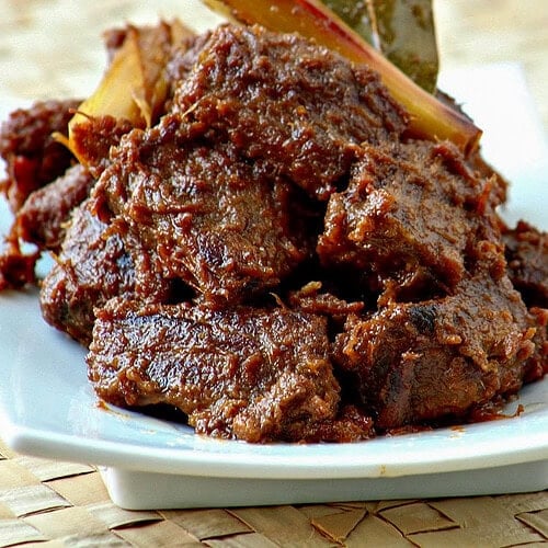This classic Indonesian beef stew is slowly cooked in coconut milk and spices until the meat is melt-in-your-mouth tender, caramelized, and super-tasty! Seriously, the best beef curry ever – Beef Rendang.
