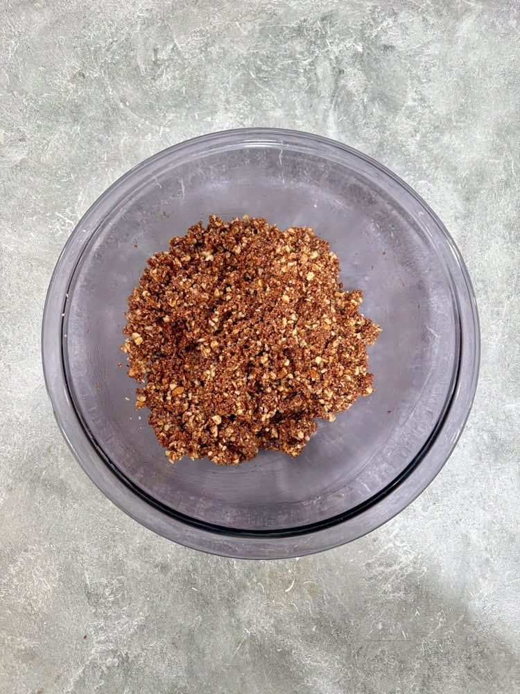 Mix in the crushed biscuits and chopped nuts until fully combined and sticky.