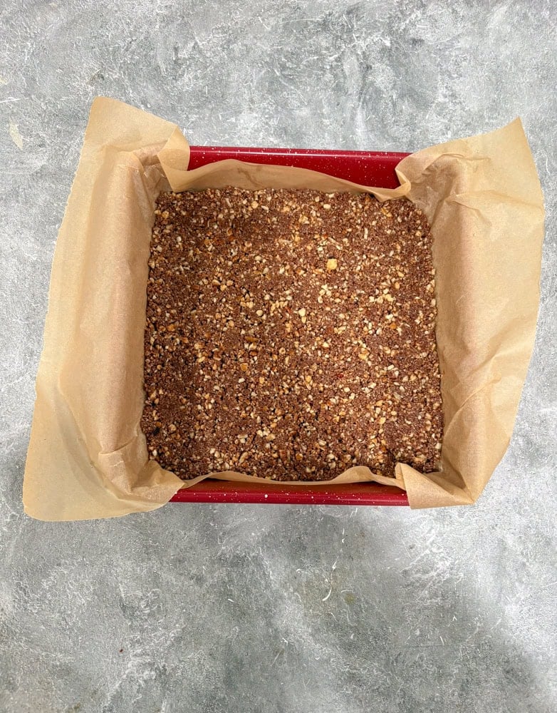 Press the mixture evenly and firmly into the pan. Refrigerate while preparing the caramel (or at least 15 minutes).
