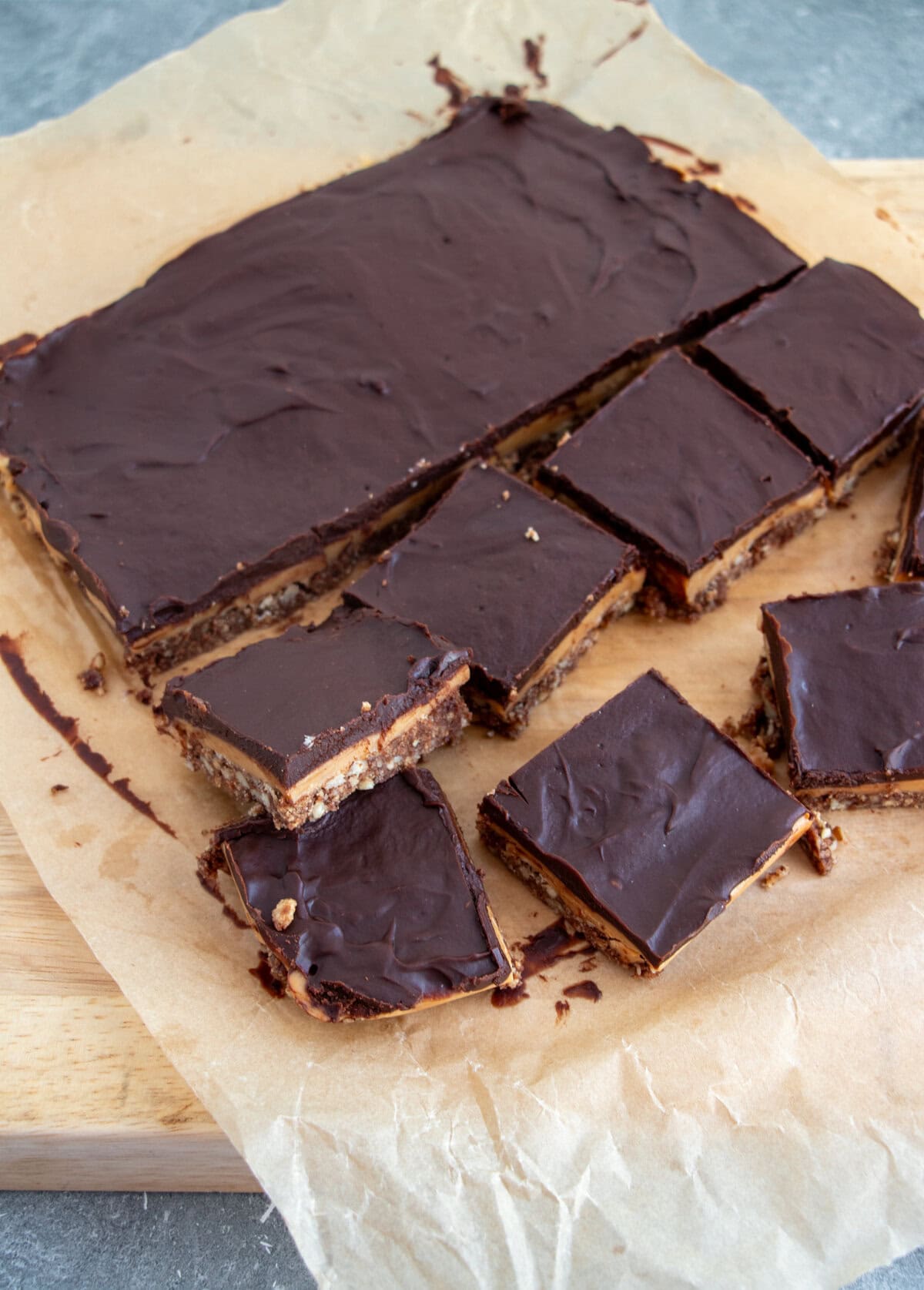 Indulgent no-bake chocolate caramel crunch bars with three irresistible layers—pecan biscuit crust, homemade golden caramel, and silky chocolate ganache.