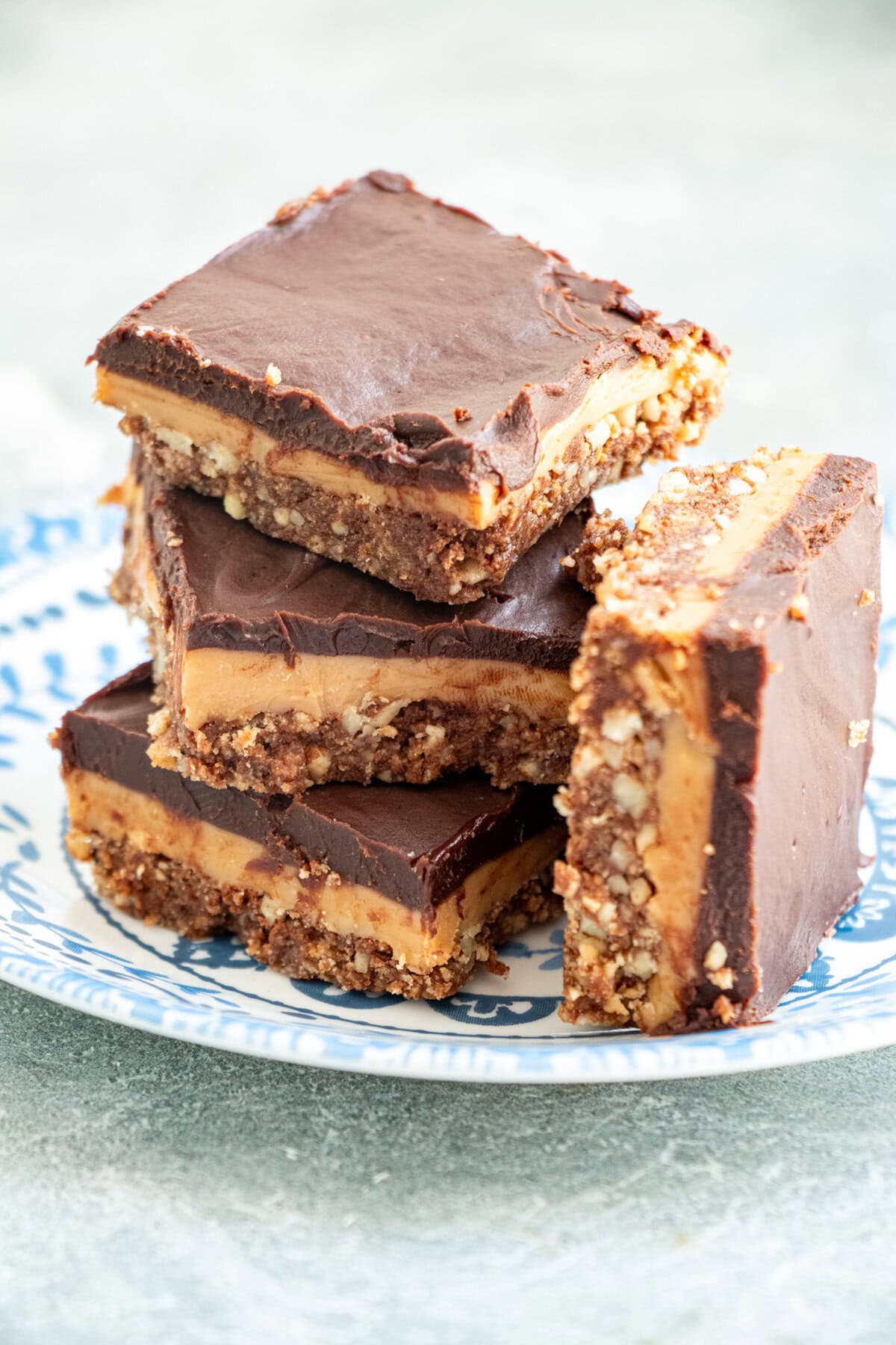 Layers of pecan crumb crust, delicious caramel filling and then melted chocolate on top - how can you resist these No Bake Chocolate and Caramel Crunch Bars? #nobake #chocolate #caramel #bars #desserts #sweets
Indulgent no-bake chocolate caramel crunch bars with three irresistible layers—pecan biscuit crust, homemade golden caramel, and silky chocolate ganache. Ready in under 30 minutes active time, perfect for summer entertaining. Easy make-ahead dessert that serves a crowd!