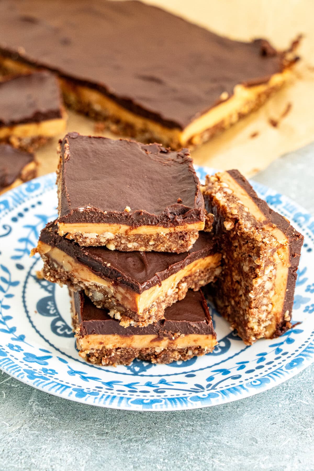 Indulgent no-bake chocolate caramel crunch bars with three irresistible layers—pecan biscuit crust, homemade golden caramel, and silky chocolate ganache. Ready in under 30 minutes active time, perfect for summer entertaining. Easy make-ahead dessert that serves a crowd!