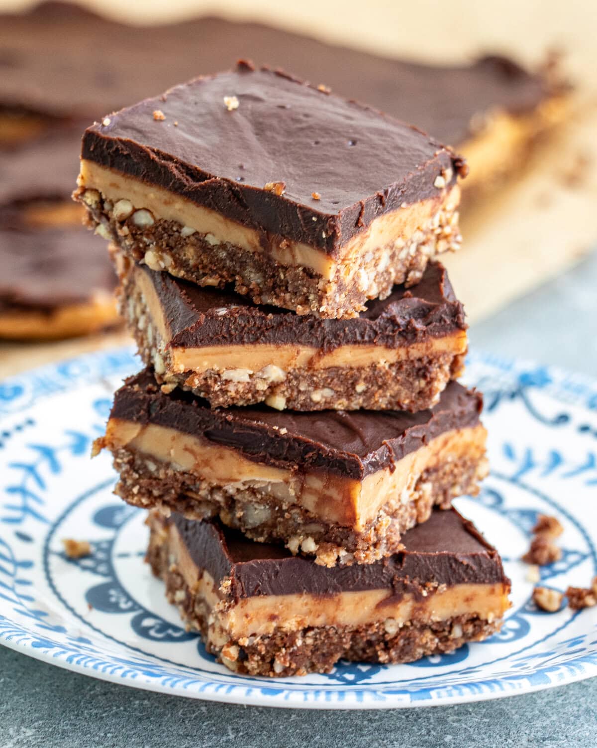 Layers of pecan crumb crust, delicious caramel filling and then melted chocolate on top - how can you resist these No Bake Chocolate and Caramel Crunch Bars? #nobake #chocolate #caramel #bars #desserts #sweets Indulgent no-bake chocolate caramel crunch bars with three irresistible layers—pecan biscuit crust, homemade golden caramel, and silky chocolate ganache.