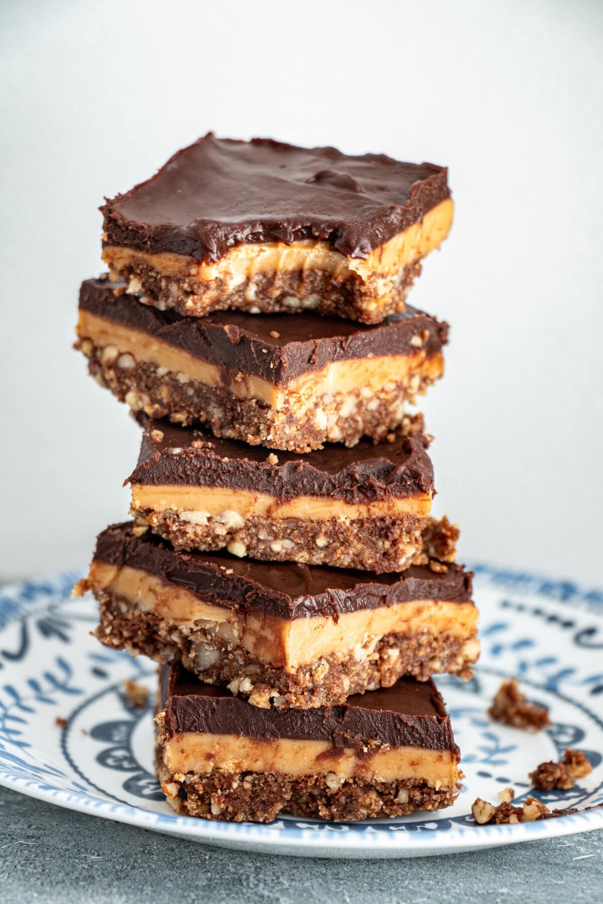 Layers of pecan crumb crust, delicious caramel filling and then melted chocolate on top - how can you resist these No Bake Chocolate and Caramel Crunch Bars? #nobake #chocolate #caramel #bars #desserts #sweets
Indulgent no-bake chocolate caramel crunch bars with three irresistible layers—pecan biscuit crust, homemade golden caramel, and silky chocolate ganache. Ready in under 30 minutes active time, perfect for summer entertaining. Easy make-ahead dessert that serves a crowd!