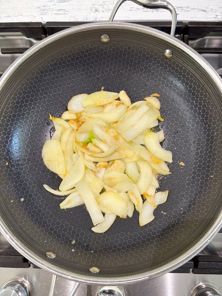 Add the grated fresh ginger and stir-fry until the onions are translucent, about 3-4 minutes.