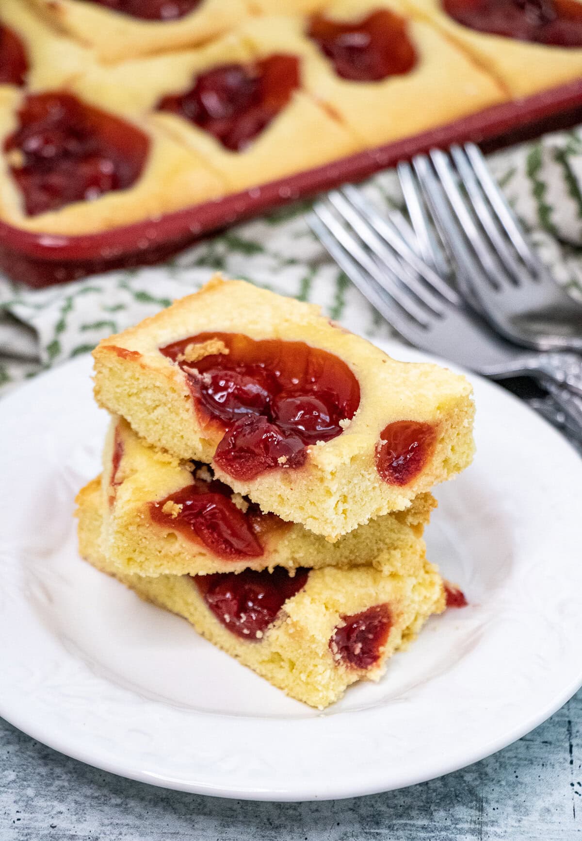 Unbelievably easy recipe for a pretty, super yummy and festive holiday dessert loaded with cherry pie filling. These Easy Cherry Holiday Squares or Bars are perfect to make for that last-minute holiday baking. Serves a crowd! #cherryholidaybars #cherryholidaysquares #christmasbaking #holidaybaking