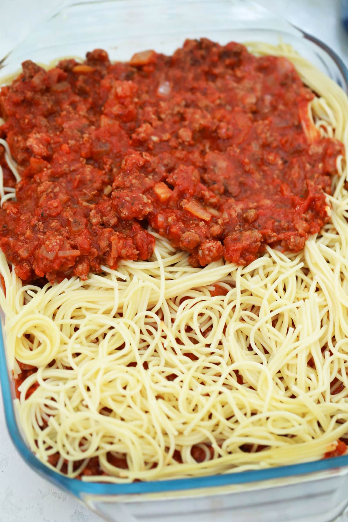 Place half of the cooked spaghetti in the prepared dish, spreading it evenly. Top with the cream cheese mixture, spreading it evenly over the pasta. Spoon half of the meat sauce all over the pasta.