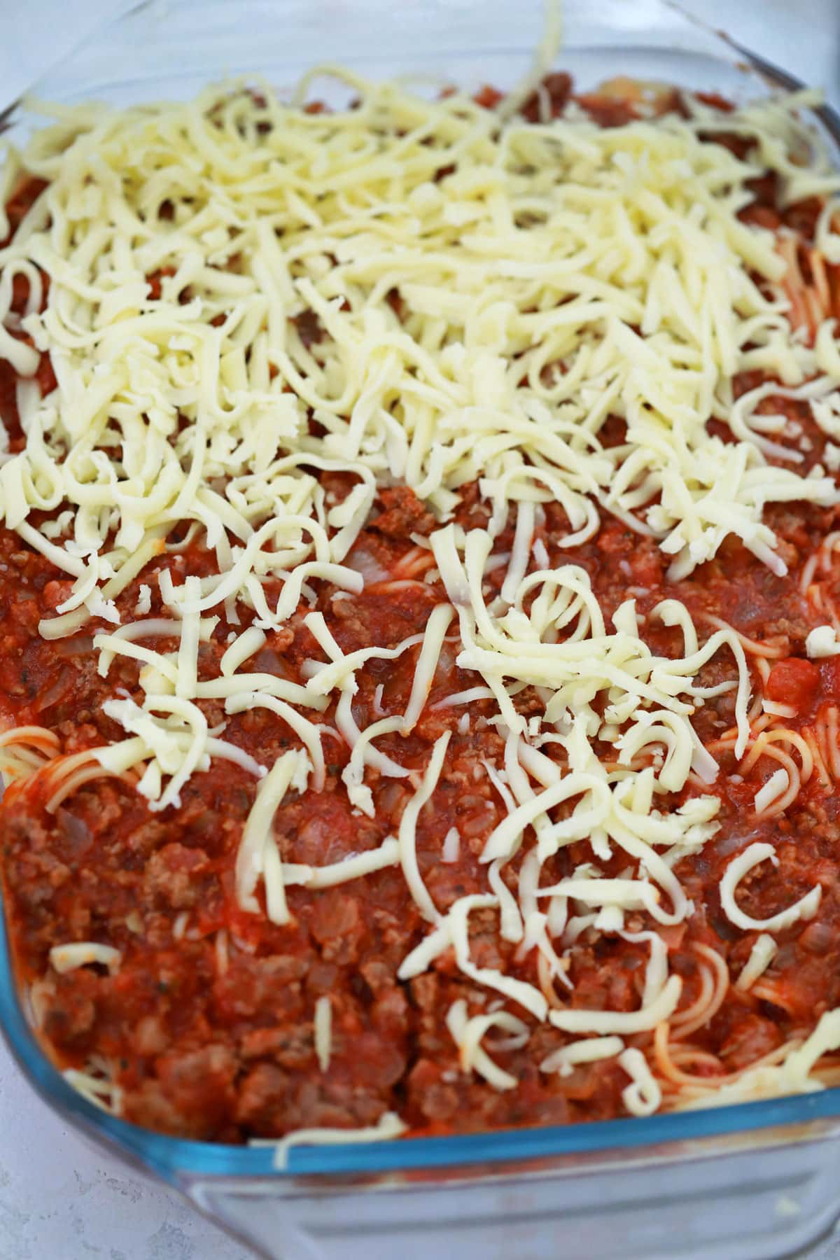Repeat the layer one more time, starting with the pasta and ending with the shredded cheese sprinkled over the top.