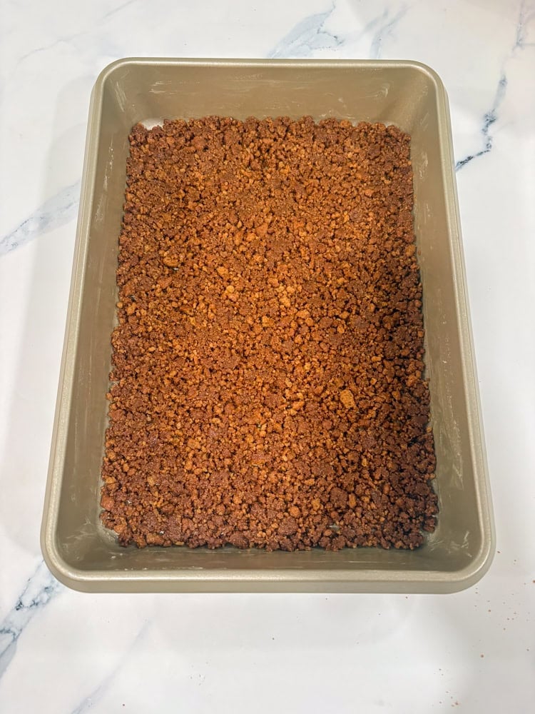 Press firmly into an even layer on the bottom of the pan (use the bottom of a measuring cup).
