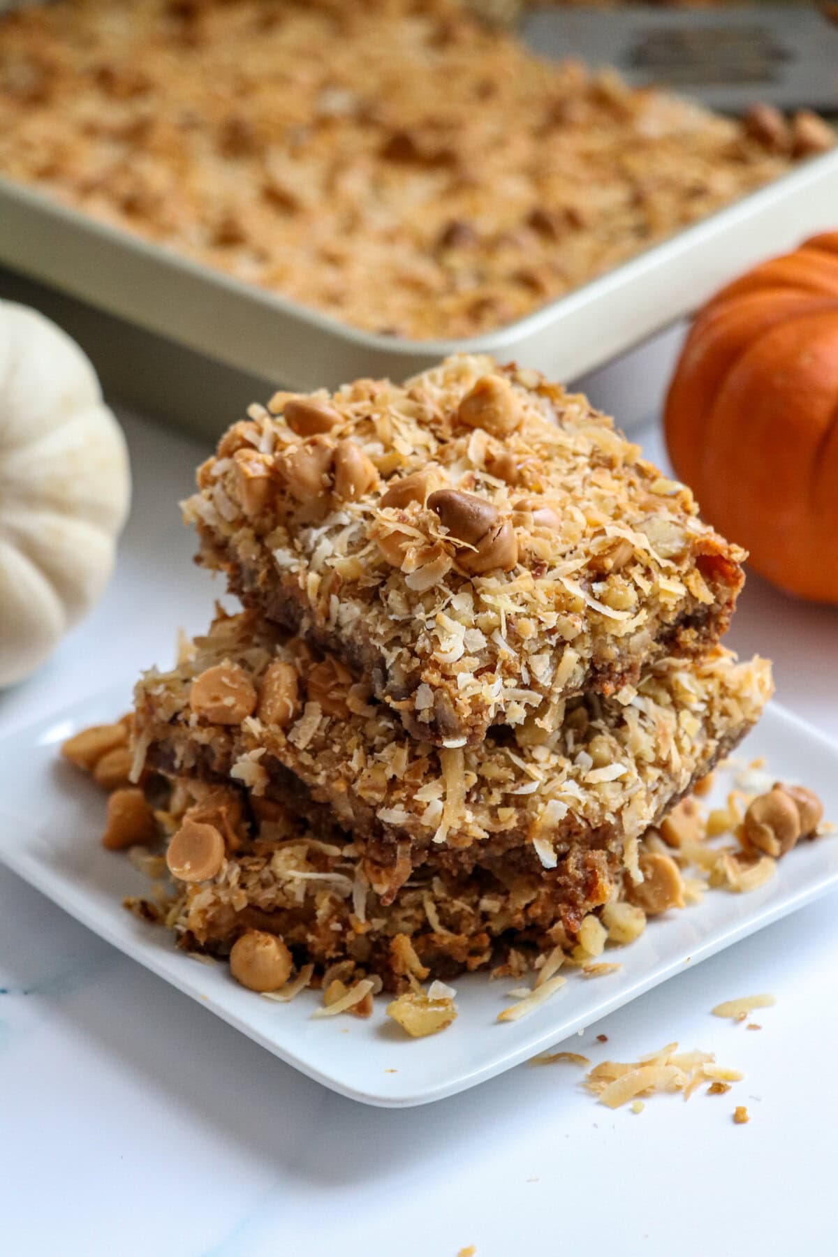 The classic favorite magic bars get a fall-inspired make-over with the addition of pumpkin puree and pumpkin pie spice in these Easy Magic Pumpkin Bars. So yummy and most of all crazy easy to make! 7 layers of deliciousness with every bite of this scrumptious fall dessert! The classic magic bar with a fall makeover: pumpkin magic Bars!