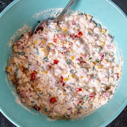 This easy and creamy corn dip (also known as Crack Corn Dip) is a type of dip or spread made with canned Mexican-style corn, cheese, sour cream, mayonnaise, chilies, and green onions. The ingredients are typically mixed together and served cold though sometimes baked or heated until the cheese is melted and bubbly. This dip is often served with corn chips as a snack or appetizer for game day, during holidays, or other special events.