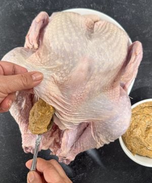 spreading mayonnaise rub all over the turkey