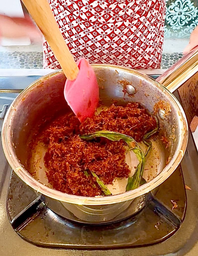 cooking the mix of coconut and palm sugar with pandan leaf