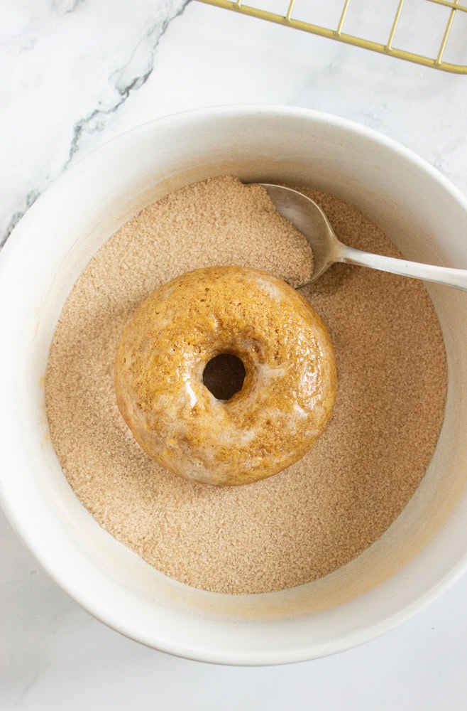 coating donuts in cinnamon sugar mixture