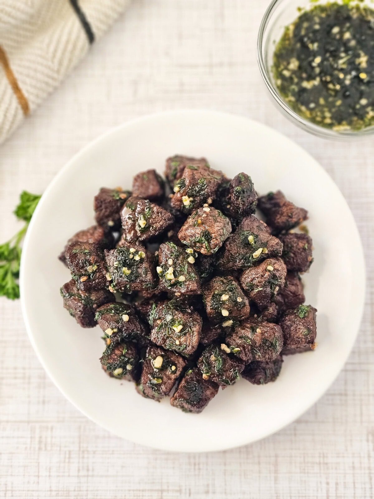 Succulent beef tapa chunks garnished with crushed garlic and herbs, served with dipping sauce, showcasing Filipino traditional cuisine. Perfect for breakfast or family gatherings.