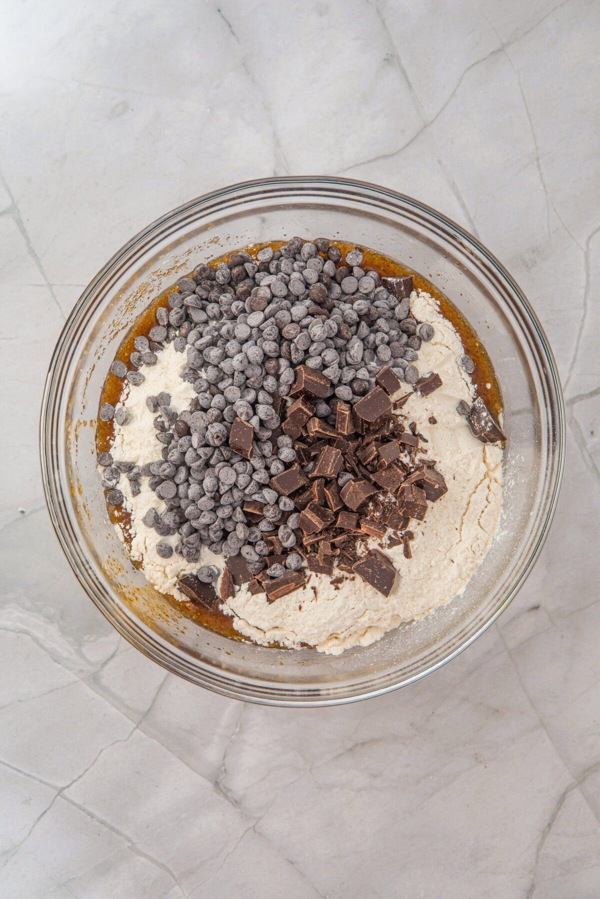 Stir until a soft dough forms, then fold in both the chocolate chips and chopped chocolate for varied texture and bursts of flavor.