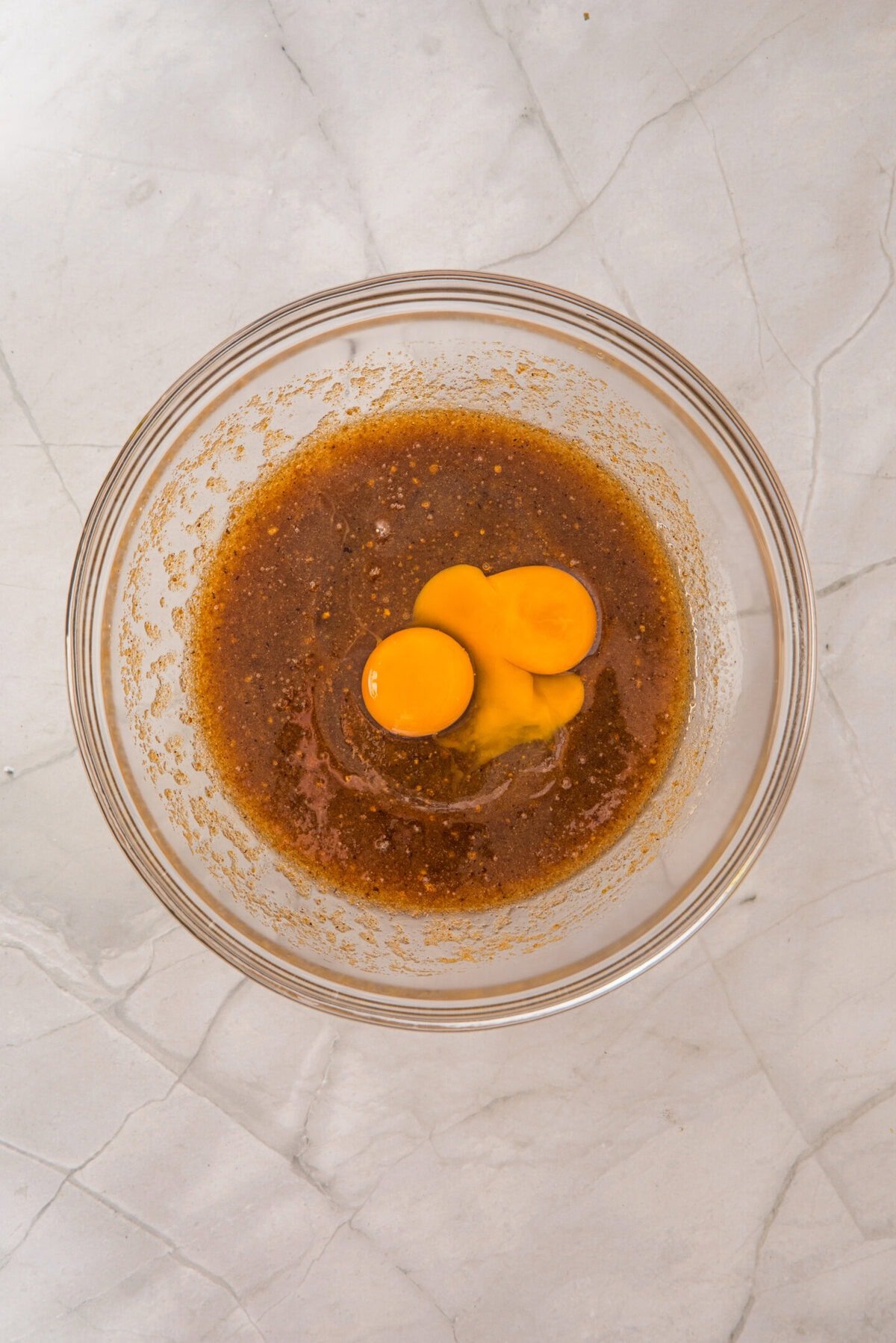 Beat in the egg, extra yolk, and vanilla extract until smooth and fully combined.