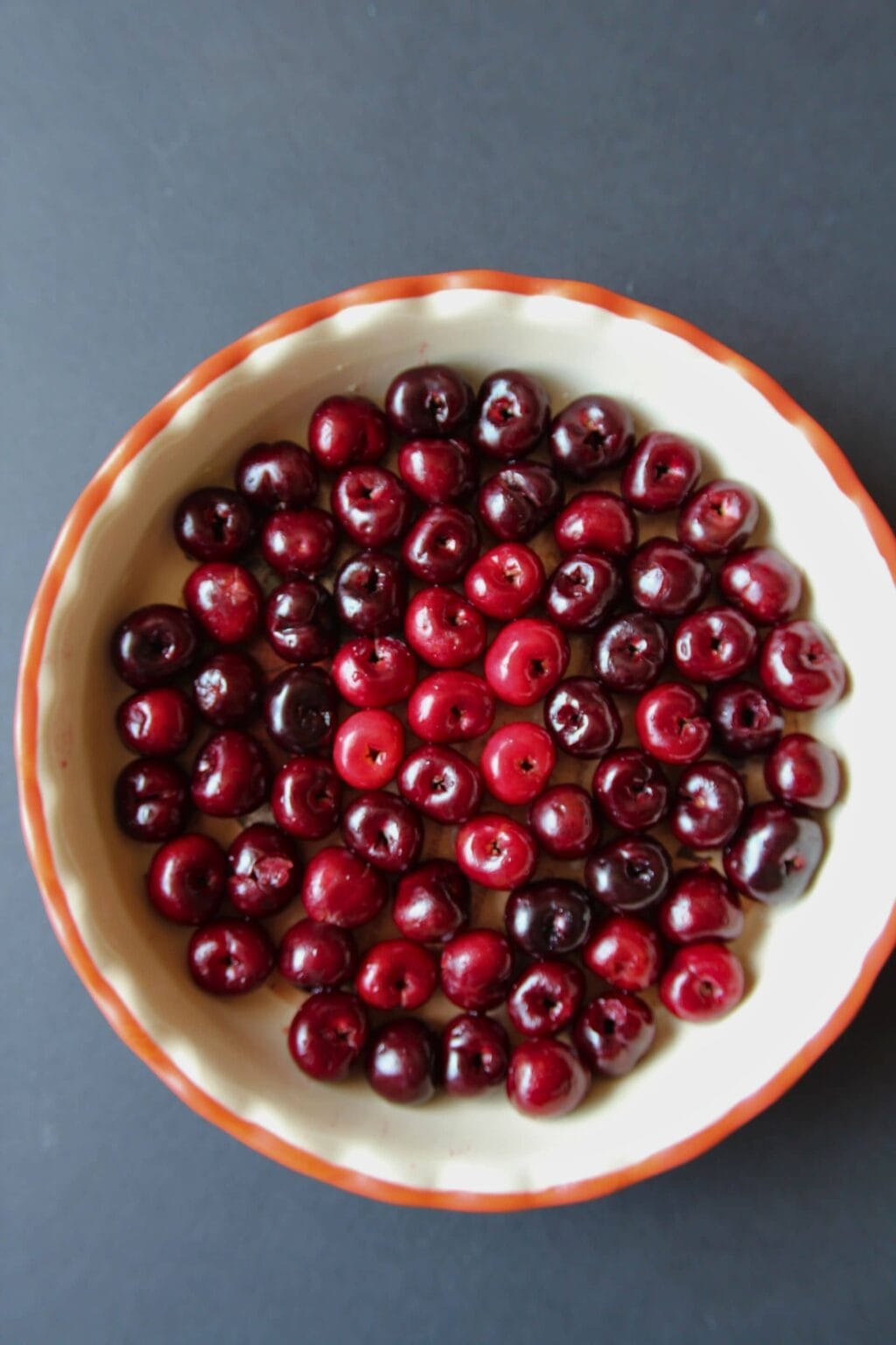 Cherries in the bottom of a 10-inch round glass or ceramic pie plate.