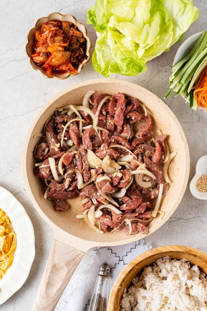 Combine the sliced beef with the onion, light soy sauce, garlic, ginger, mirin, sesame oil, and sugar; mix well and marinate for 20 minutes.