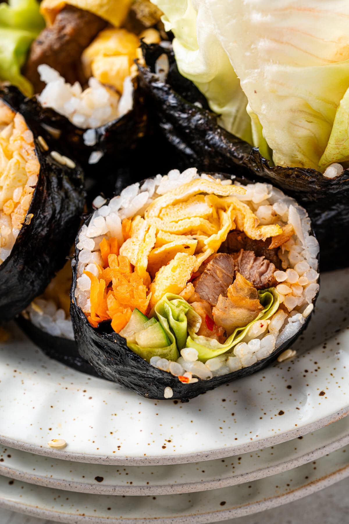 Bulgogi Kimbap with savory marinated beef, sesame rice, kimchi, egg, and crisp vegetables.