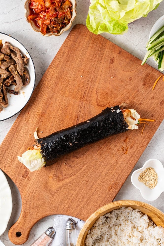 Roll tightly from the bottom, tucking in the fillings as you roll.